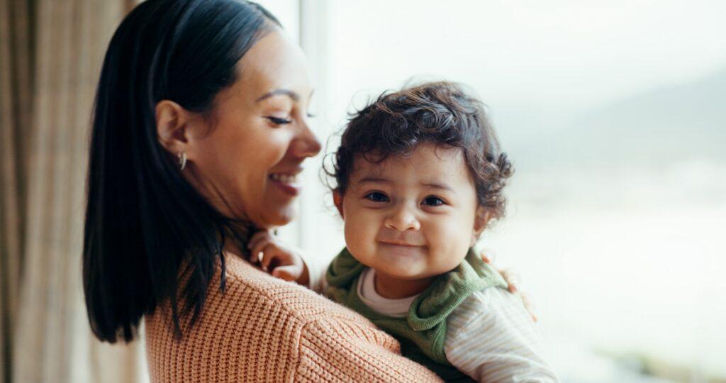 Love, happy and mother with baby at window for play, relax and quality time. Happiness, smile and h.